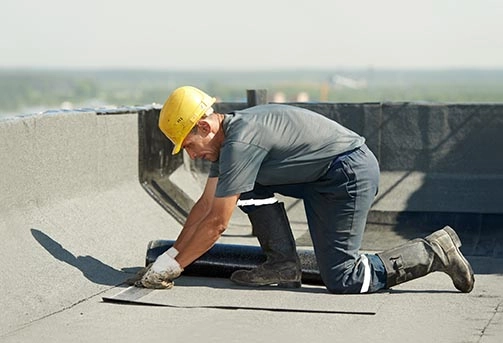 Professional roofer installing flat roofing material for a roofing company SEO campaign in Ohio