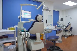 Modern dental clinic featuring advanced treatment chairs, digital equipment, overhead lights, and a clean, professional patient care environment.