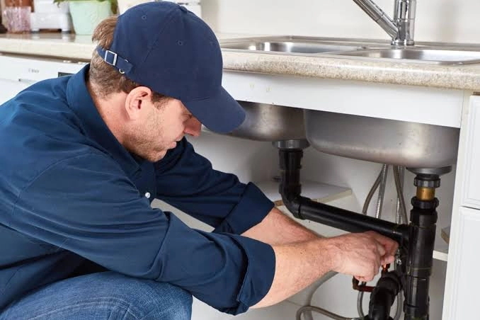 Professional plumber inspecting kitchen sink pipes in a New York home. Discover how a full SEO campaign helps plumbing businesses increase local visibility, generate leads, and attract more customers online.