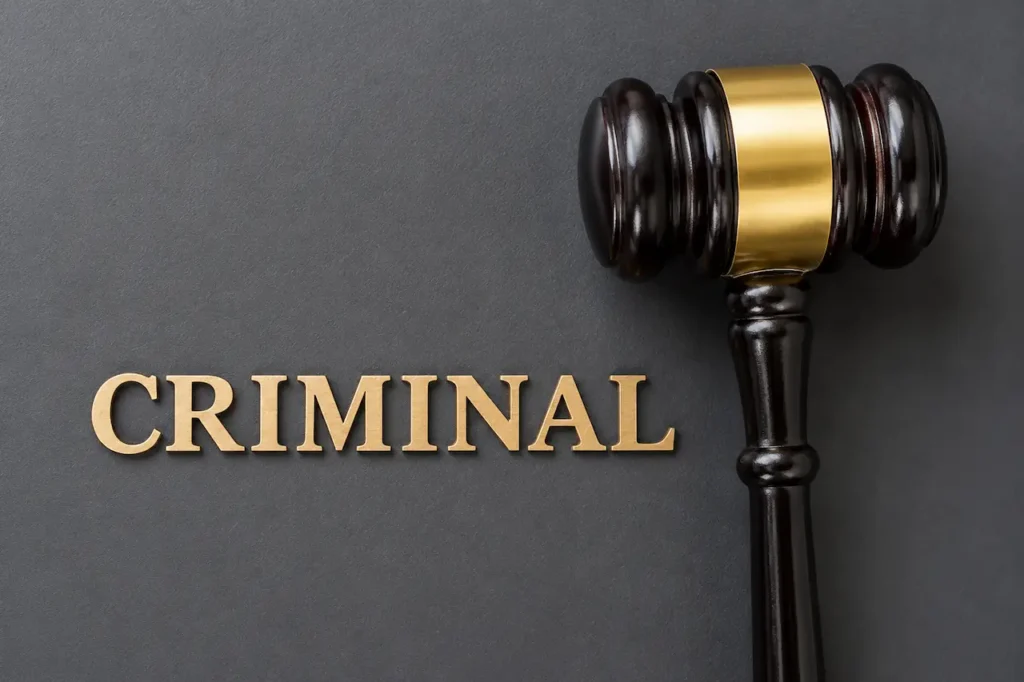 "Judge's wooden gavel beside the word Criminal on a dark background representing criminal defense law and legal services."
