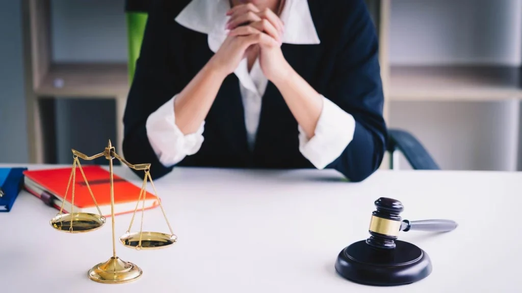 Personal injury lawyer at a desk with scales of justice and a gavel in a professional law office.