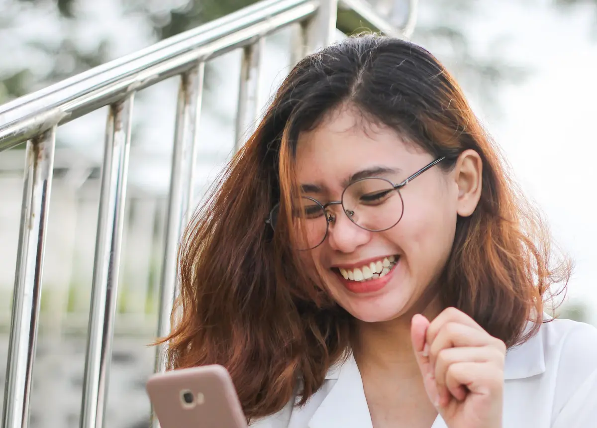 Customer smiling while chatting with a business on her smartphone
