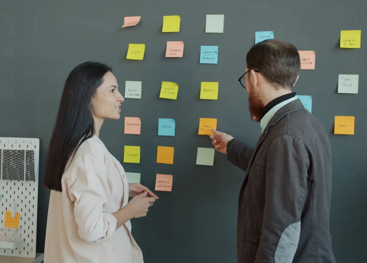 Two colleagues organising a sales pipeline with sticky notes