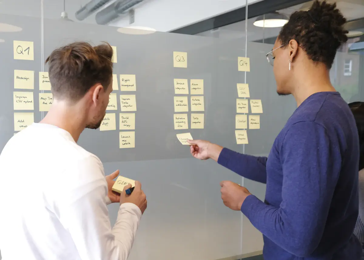 Team mapping a business process with sticky notes on a glass wall