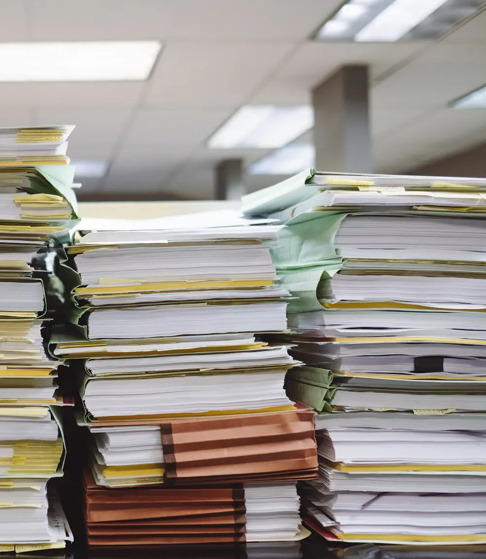 Stacks of business documents and files holding company knowledge
