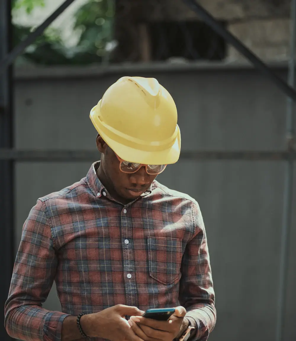Contractor in a hard hat taking a phone call on a job site