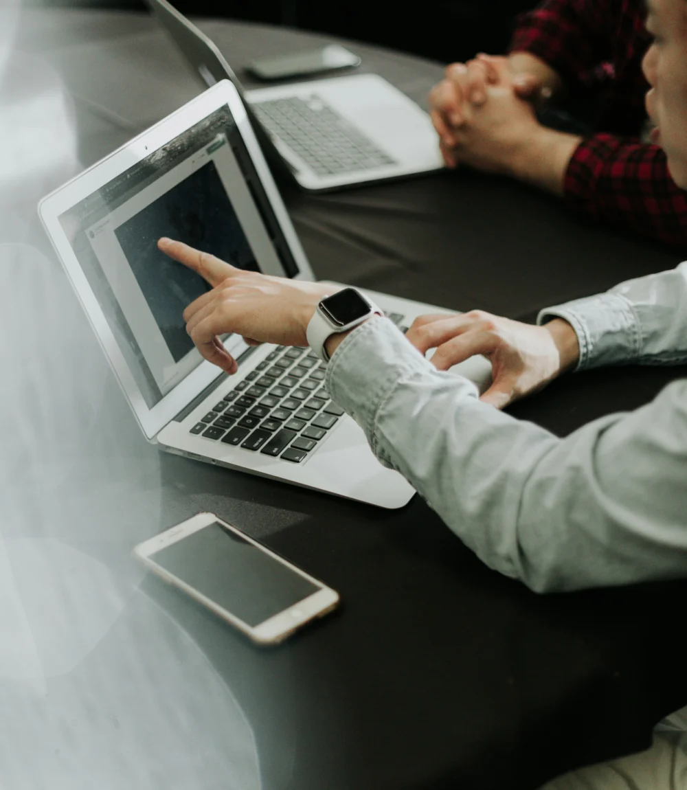 Two people planning an AI SEO strategy at a table with laptops