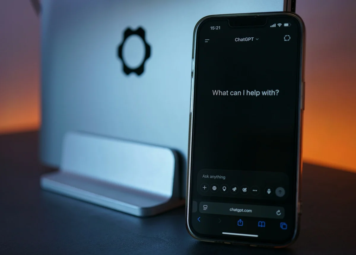 Phone showing ChatGPT next to a laptop