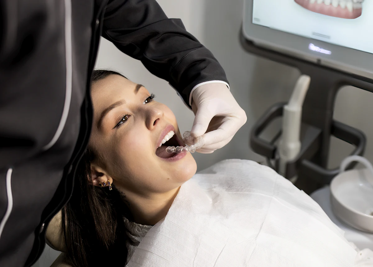 Dentist using an intraoral scanner while a patient sees her teeth on screen