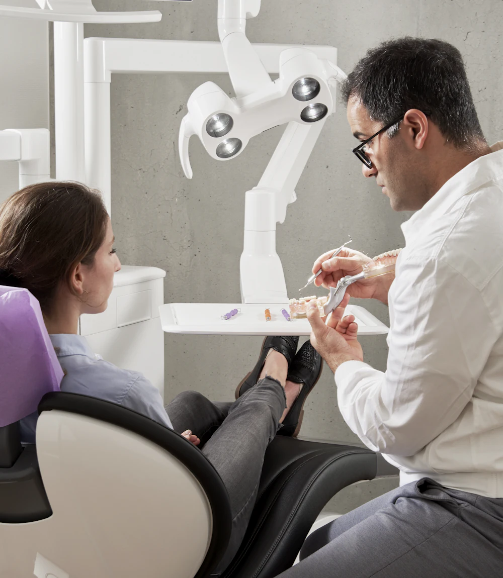 Dentist talking a patient through her treatment in a modern dental office