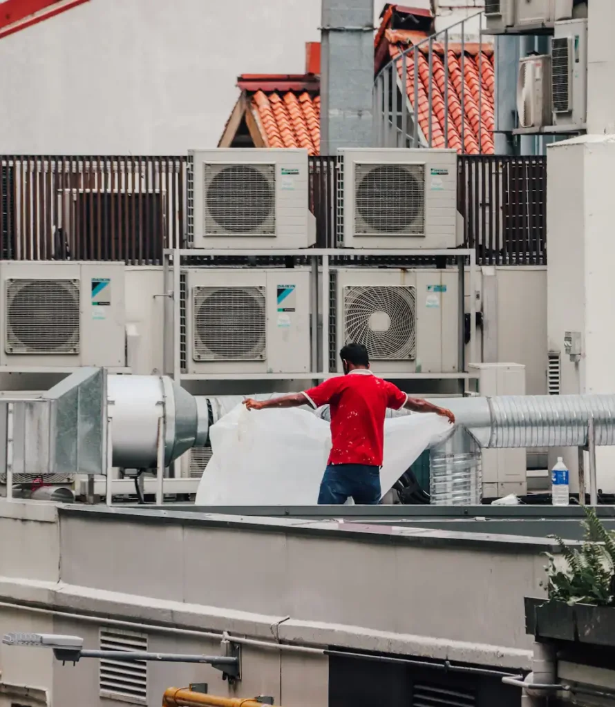 HVAC technicians working among rooftop air conditioning units on a commercial building
