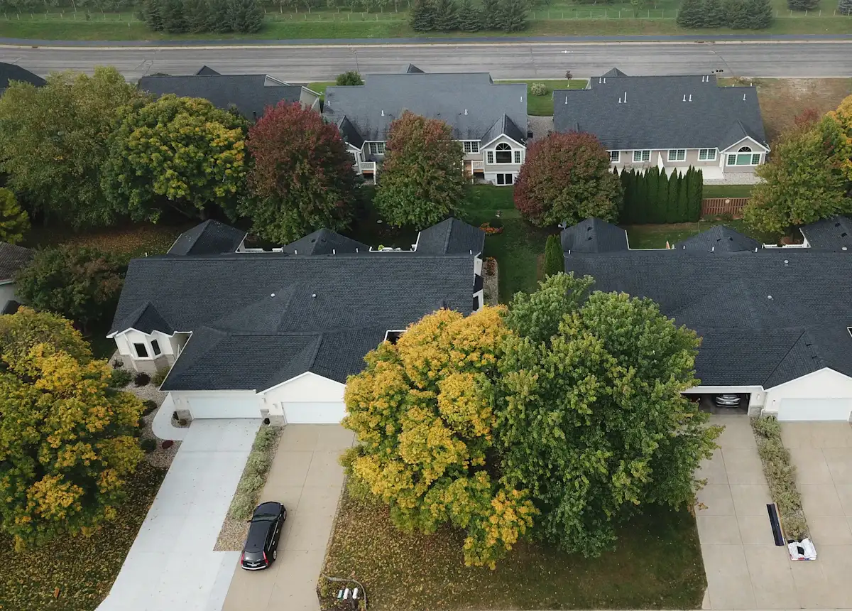 Aerial view of a US suburban neighborhood with dozens of residential roofs