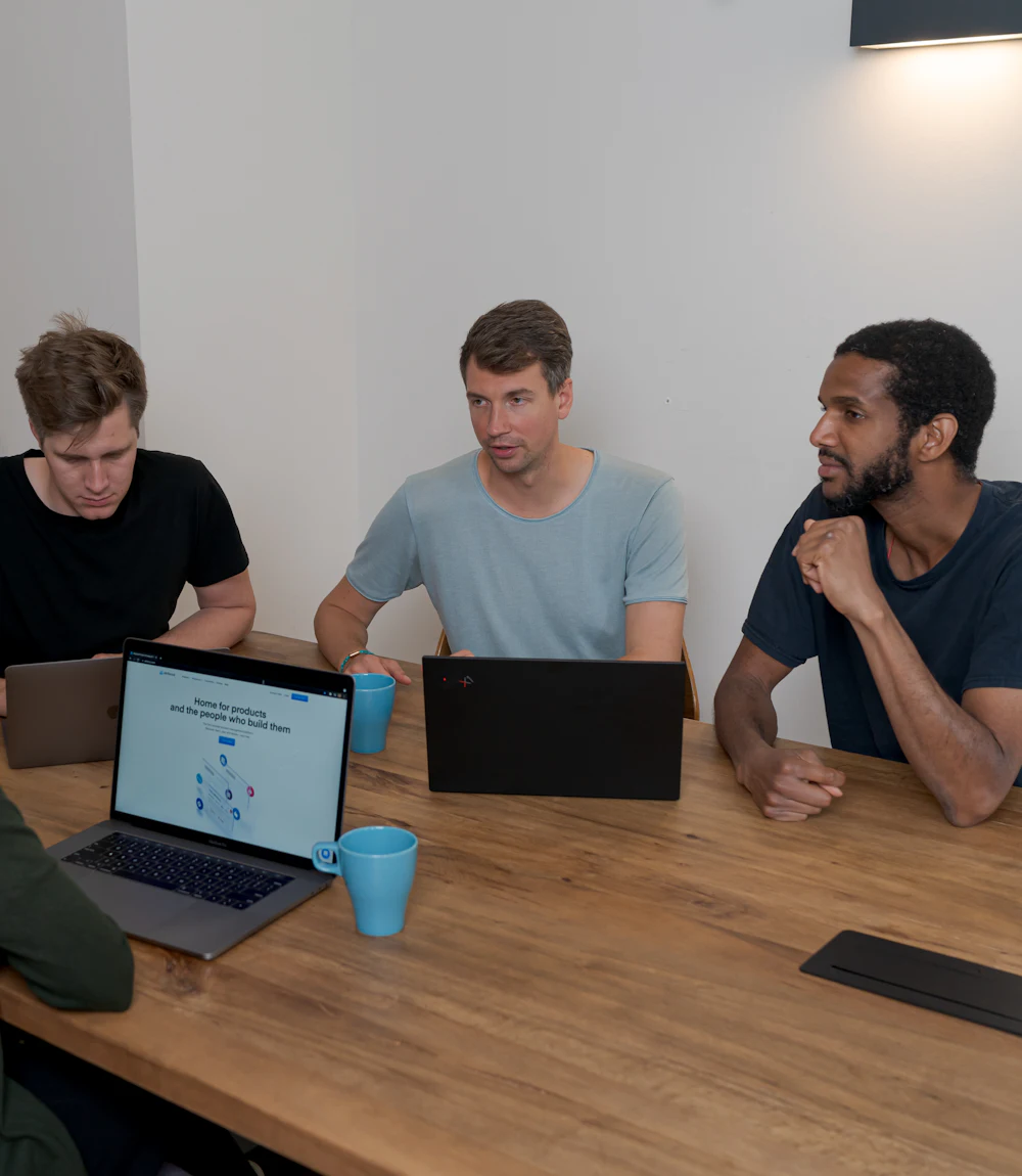 B2B SaaS team planning their go-to-market strategy around a table with laptops